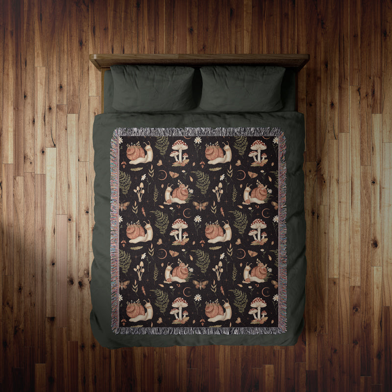 Cute snail and mushroom woven blanket on a cozy bed