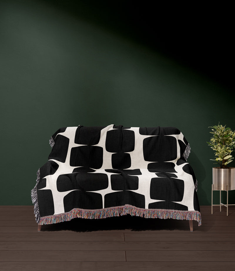 Monochrome, geometric shapes, cotton woven bedspread on a couch