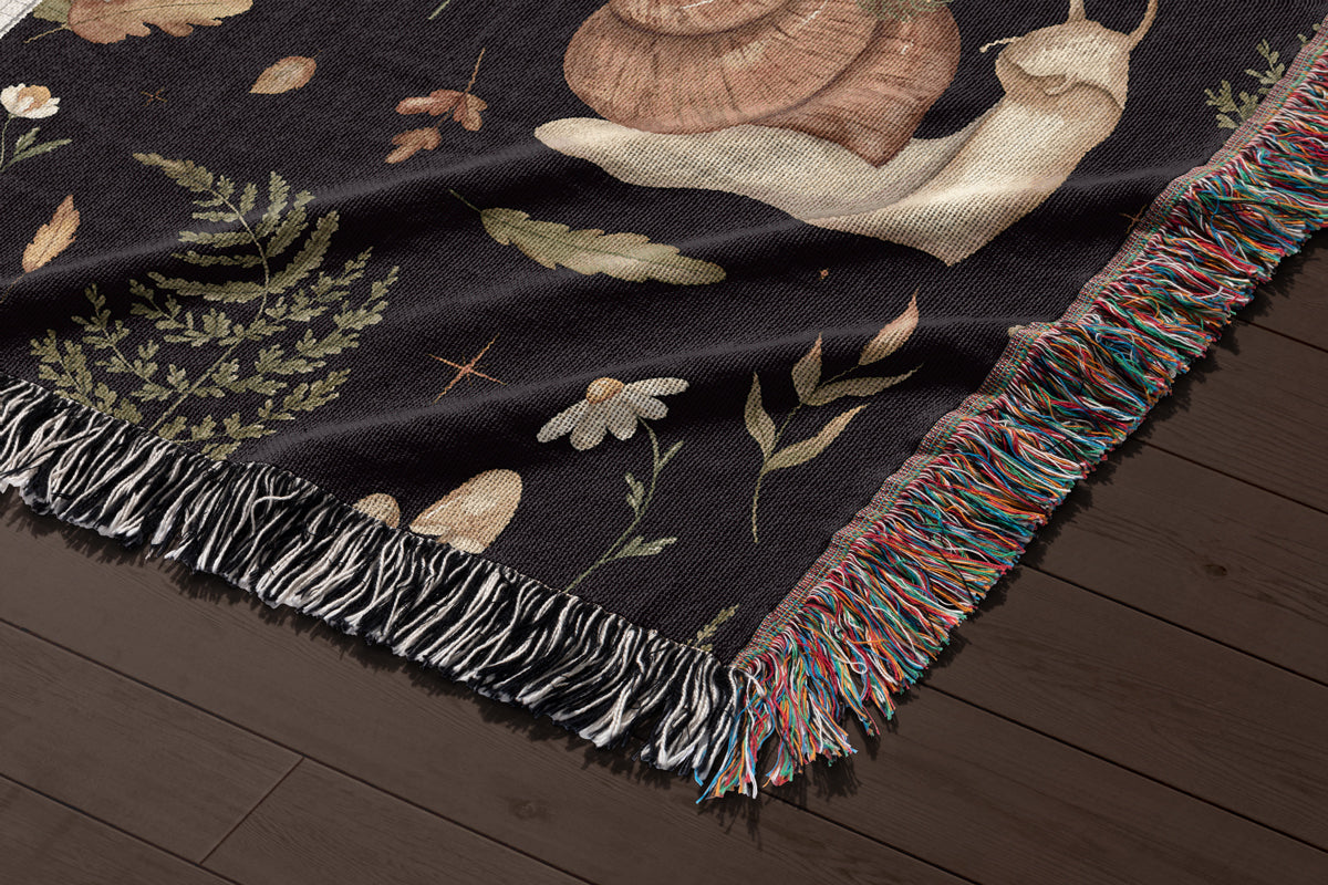 Close up of Dark Cottagecore woven blanket with snails, ferns, mushrooms